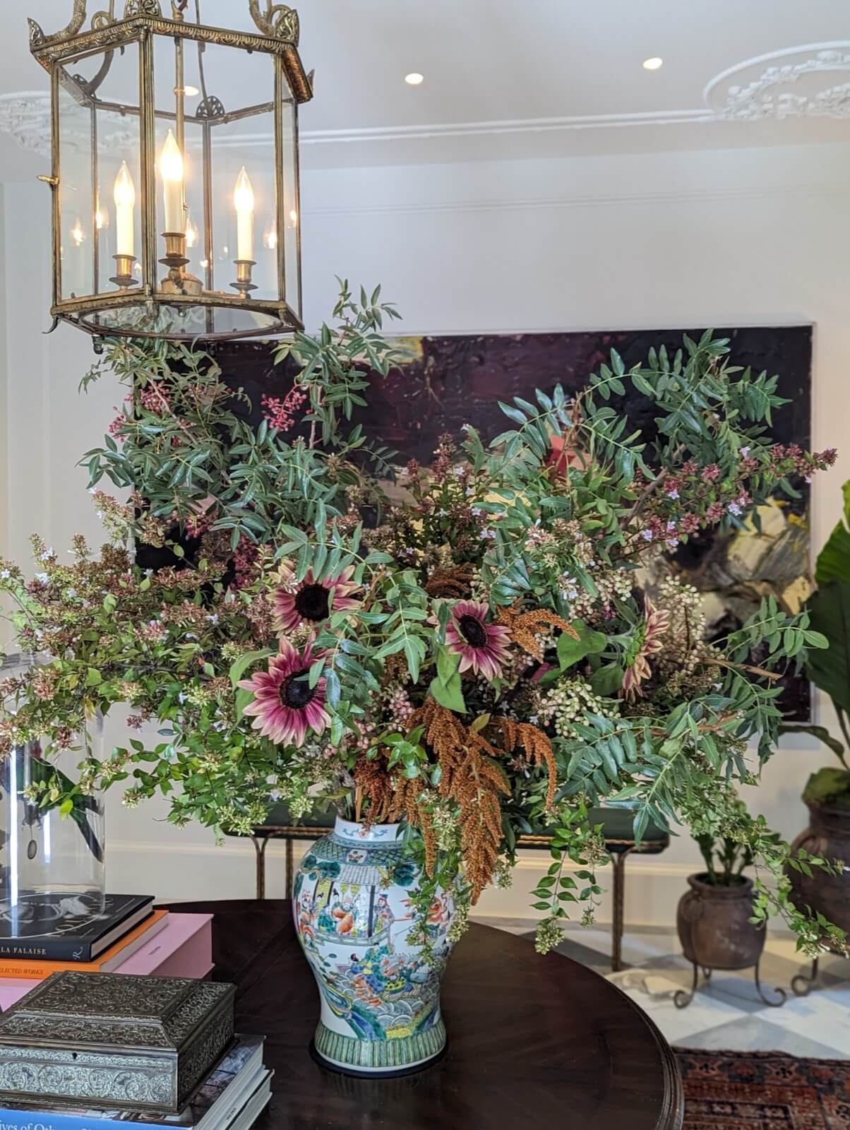 Grand arrangement of eucalyptus, jasmine, and dark anemones in a Chinese jardiniere
