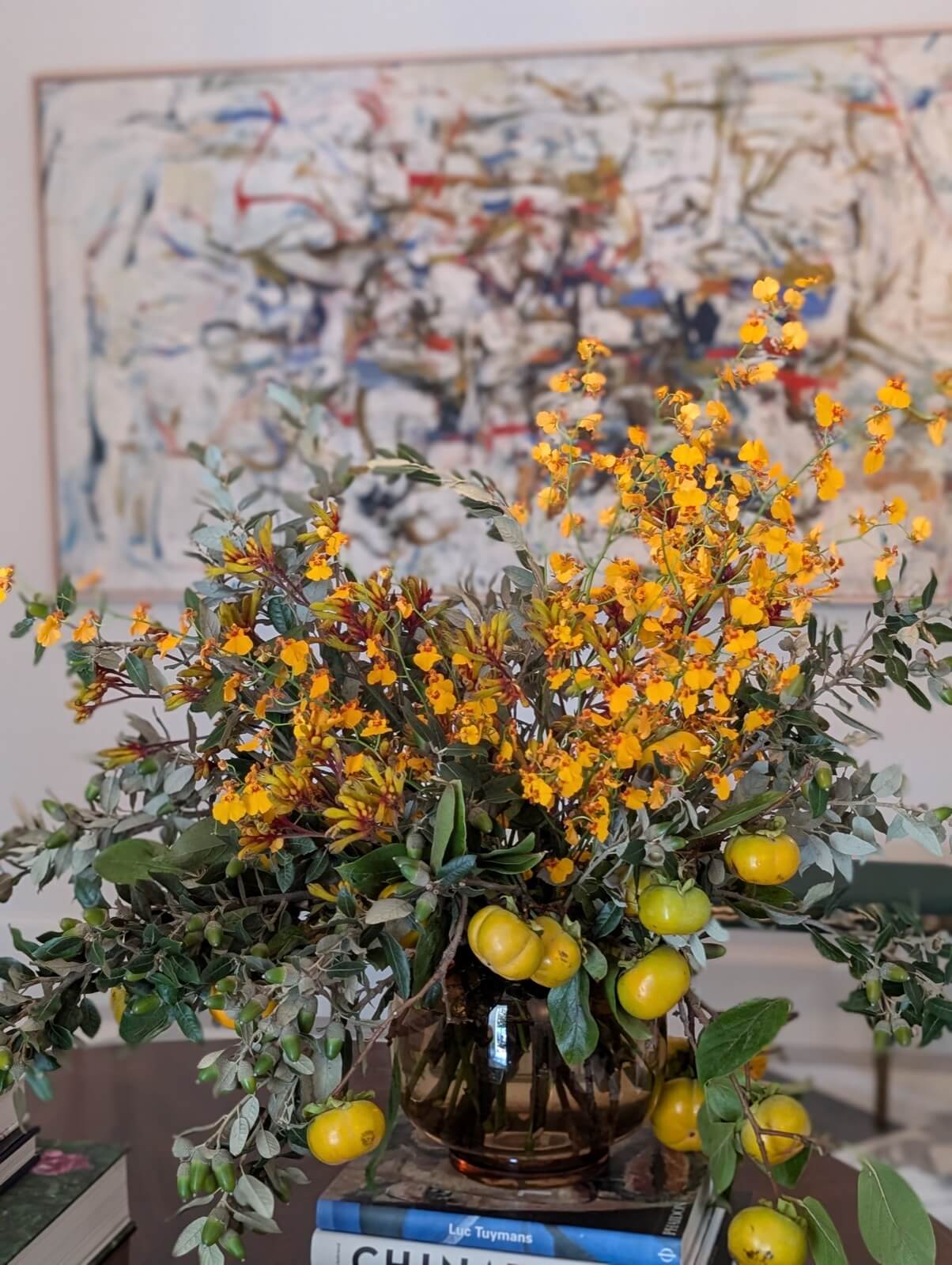 Yellow oncidium orchids and olive branches with lemons still on the stem
